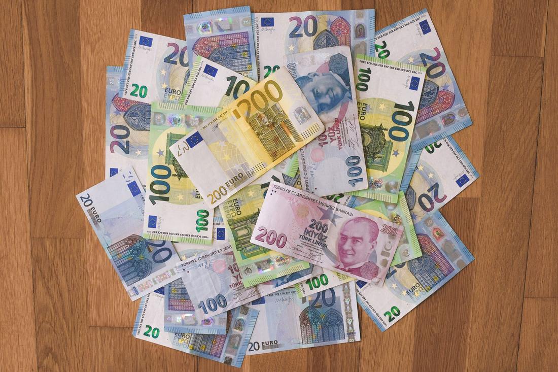 Mehrere Euro-Banknoten verschiedener Stückelungen liegen geordnet auf einer hellen Fläche
